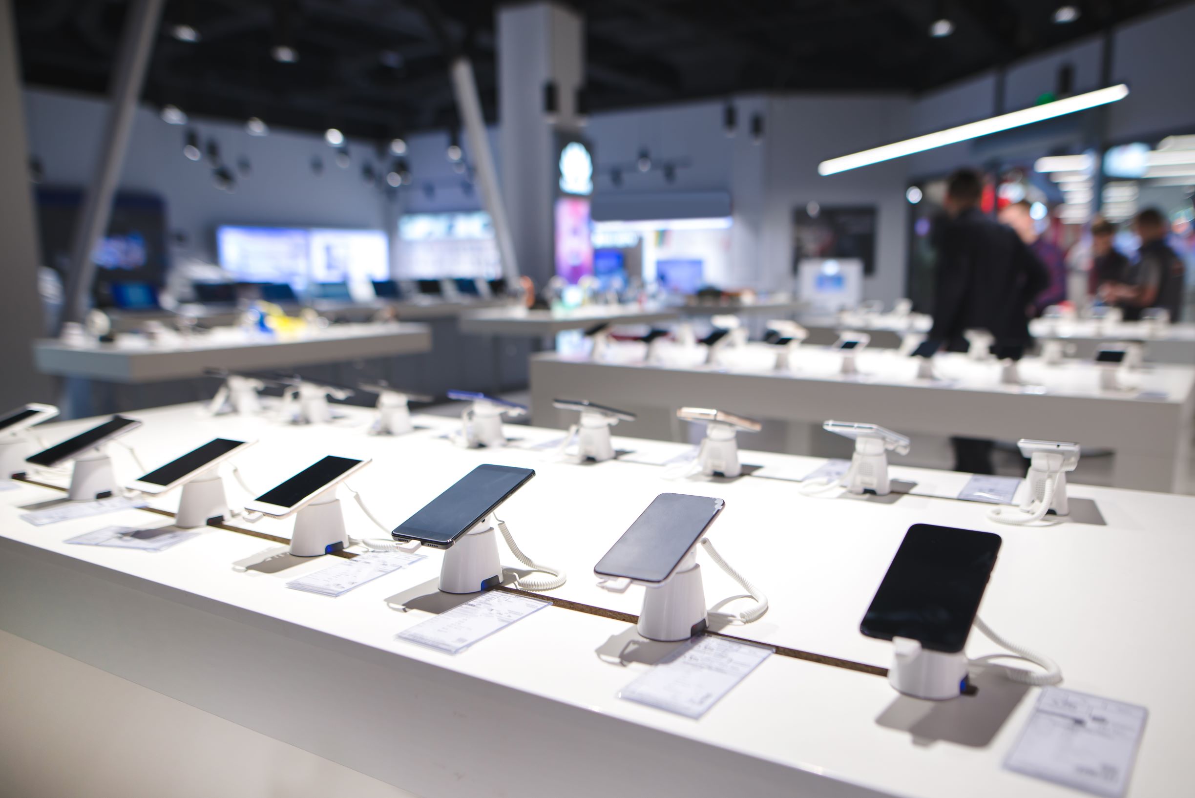 Mobile phones lined up on display at a mobile phone store